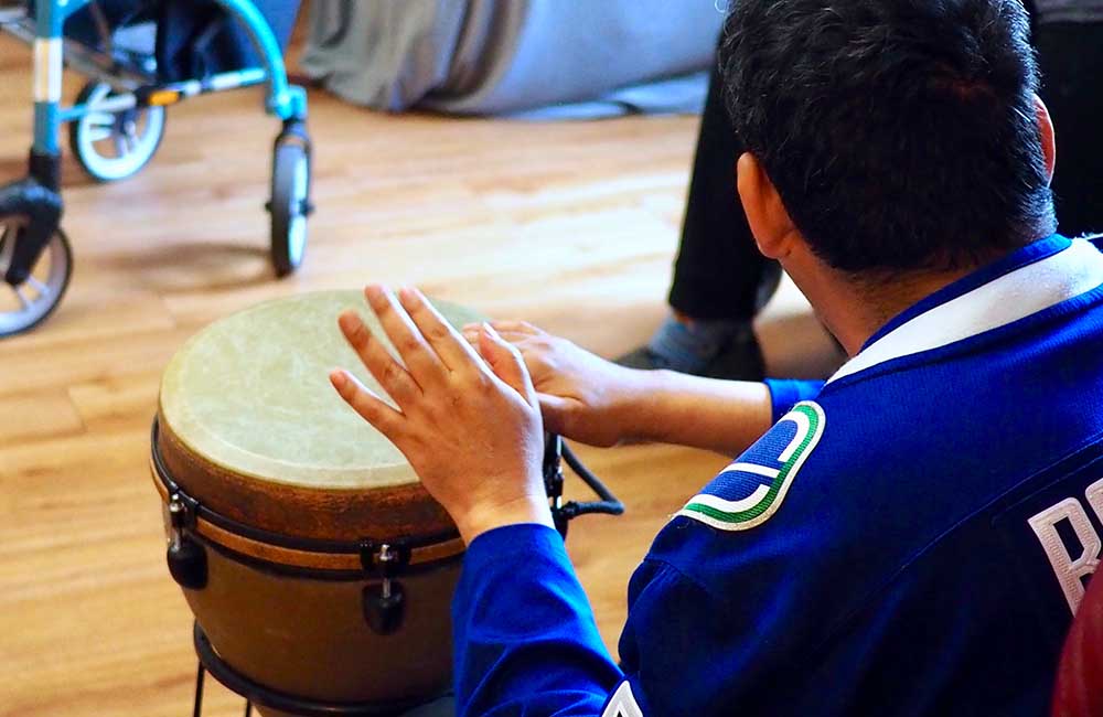 man playing drums in Canucks sweater