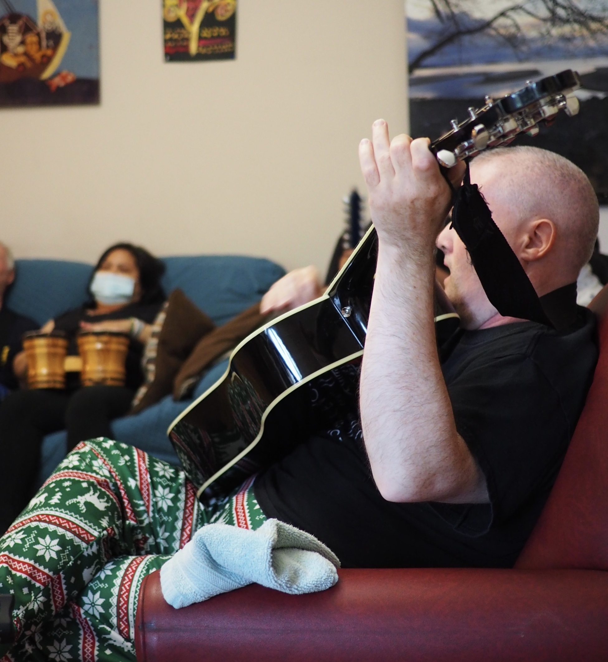 man on couch playing guitar
