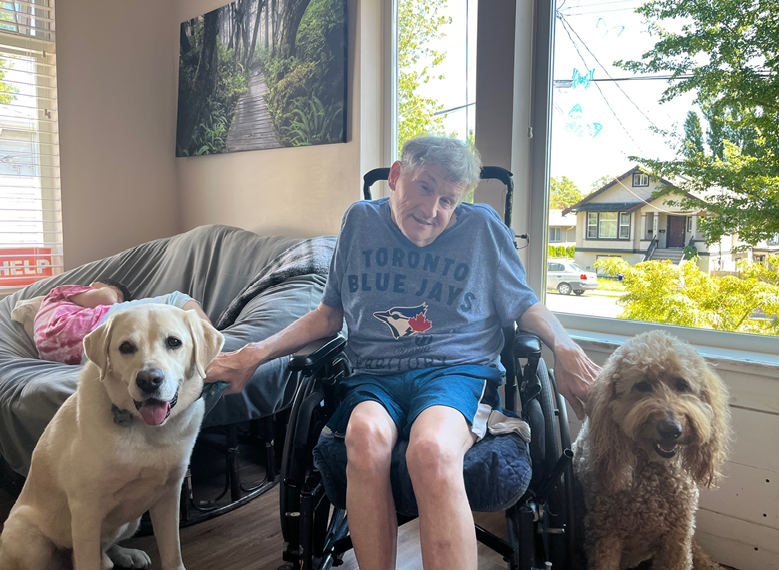 man in Blue Jays shirt with two happy dogs
